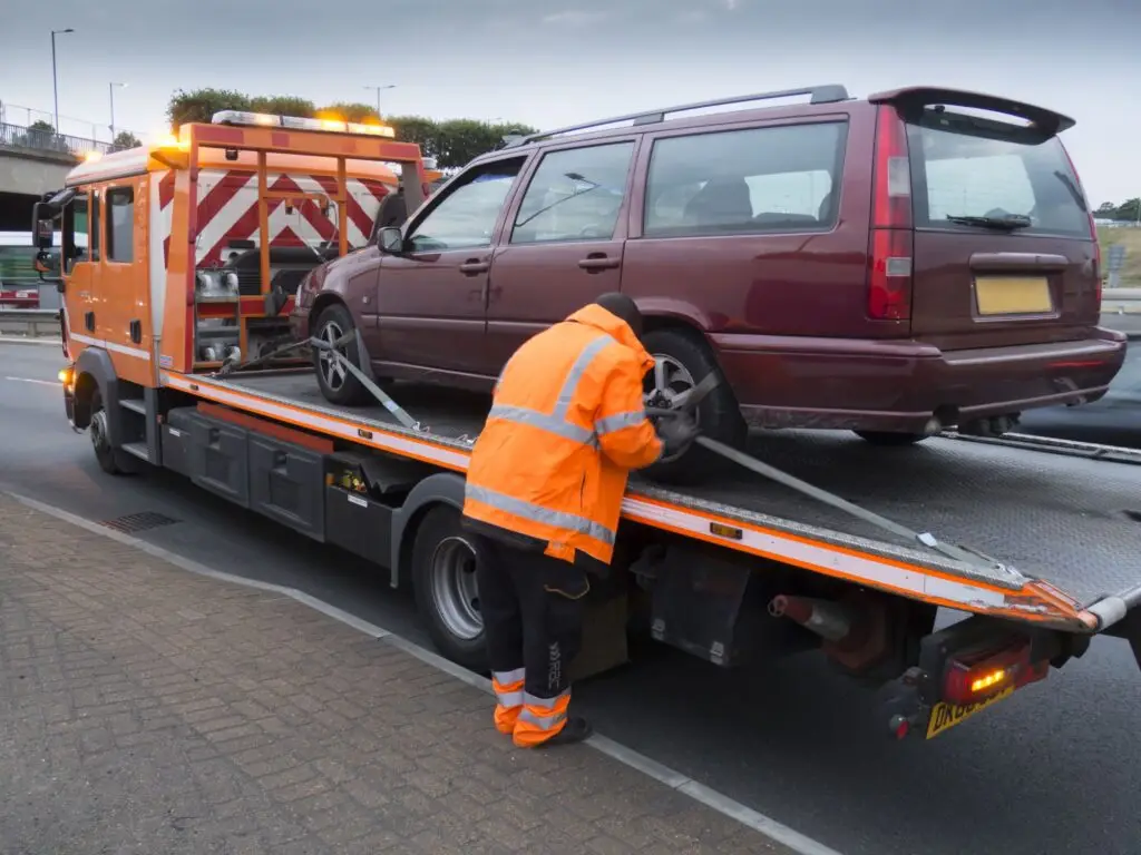 A broken down vehicle is put on a recovery truck.