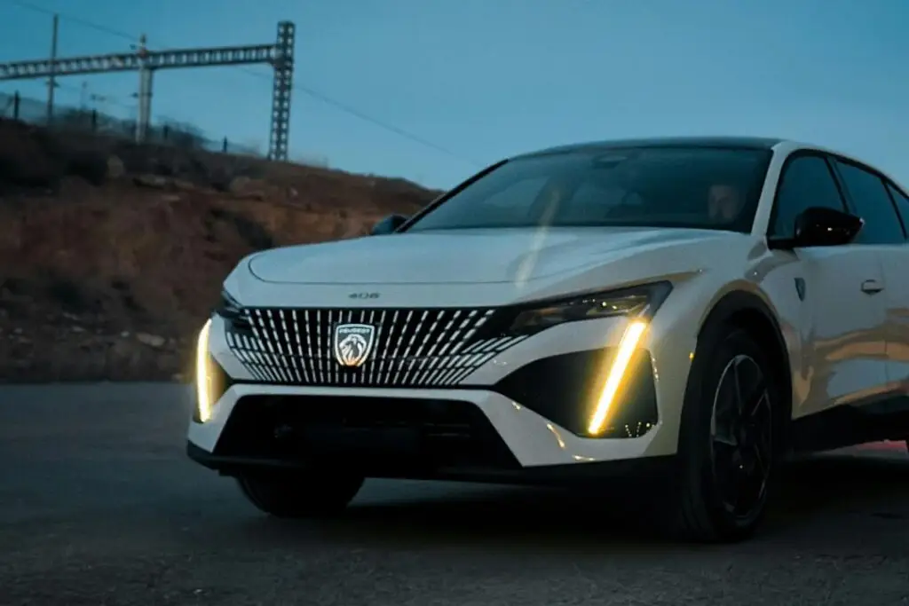 White Peugeot 408 with lights on in the dark