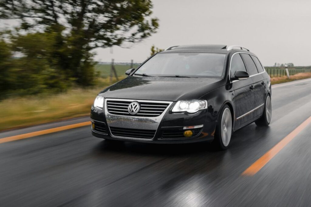 Black VW Passat Estate driving down the road