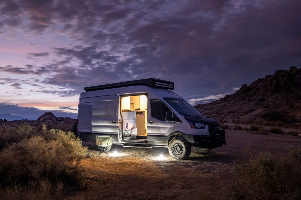 Nighttime. Converted van parked in remote field.