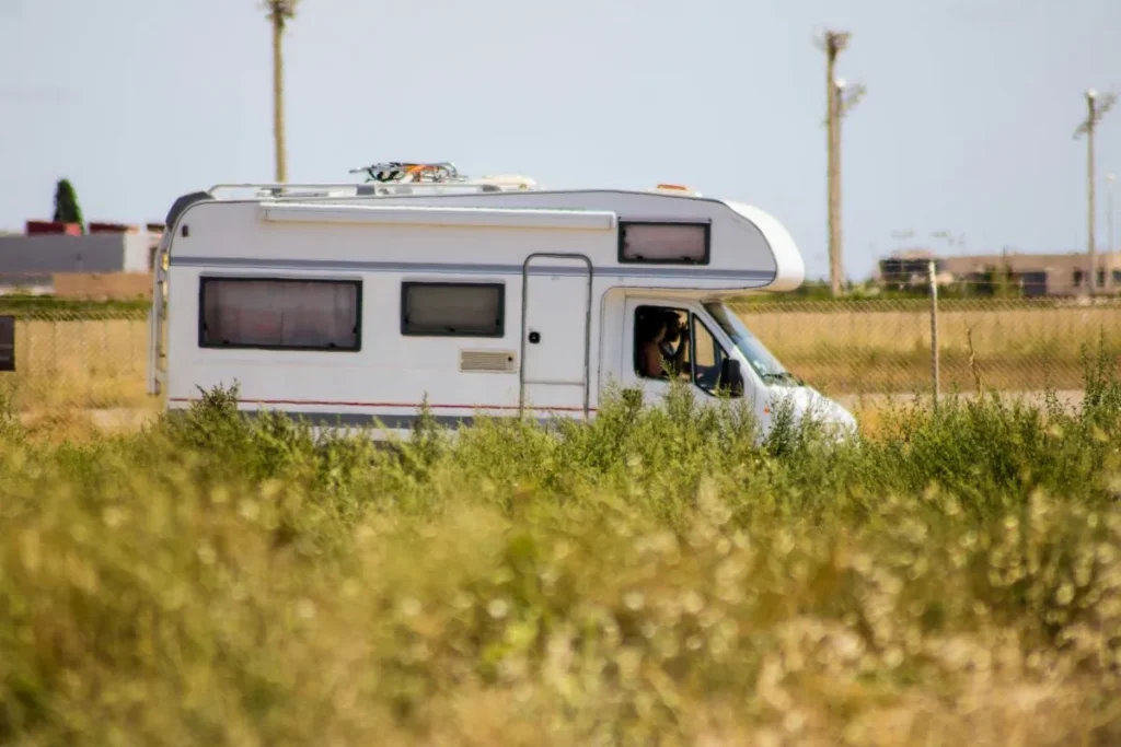 Motorhome driving down the road with grass in the foreground and background