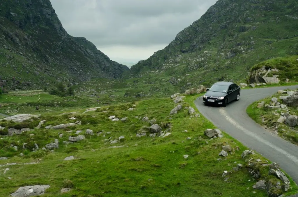 Car driving through the mountains on a narrow road